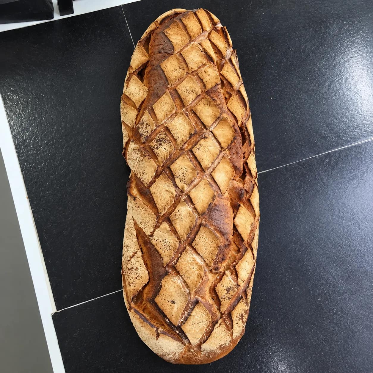 Grand pain de campagne à la croûte dorée, scarifiée en losanges